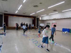 数名の子供がケンステップをしているのを数人の大人が見守っている様子
