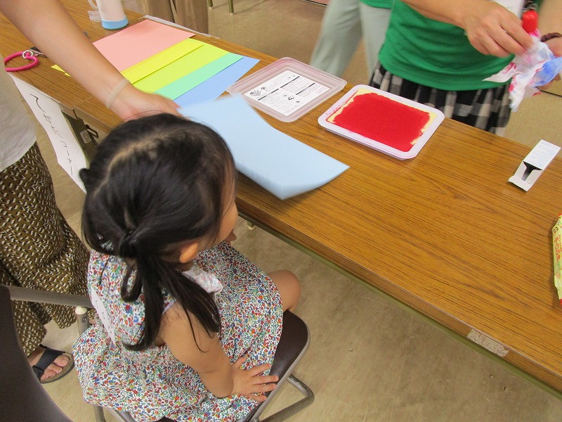 子どもが紙にスタンプを押してもらっている様子