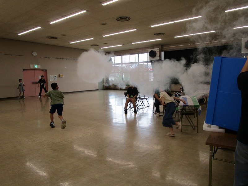空気砲で飛ばした煙を子供たちが走って追いかけている様子