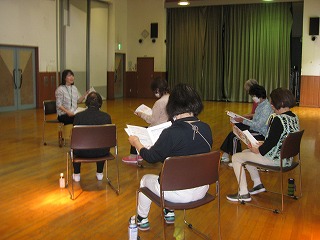 椅子に座った数名の受講者が、前方で譜面台を挟んで向かい合う講師の指導を仰いでいる様子を写した写真