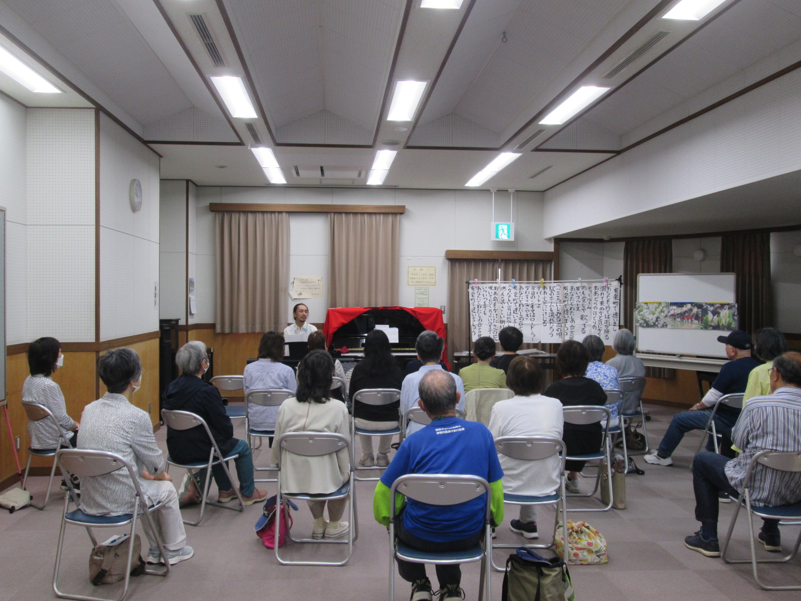 たくさんの参加者が着席して三野先生のピアノ演奏を楽しんでいる音楽会の様子の写真