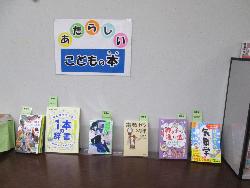 「あたらしいこどもの本」と書かれたポップの下に、読書感想文や小説、科学、気象学などの分野の新着図書と記された児童書六冊が並べられ展示されている様子を捉えた写真