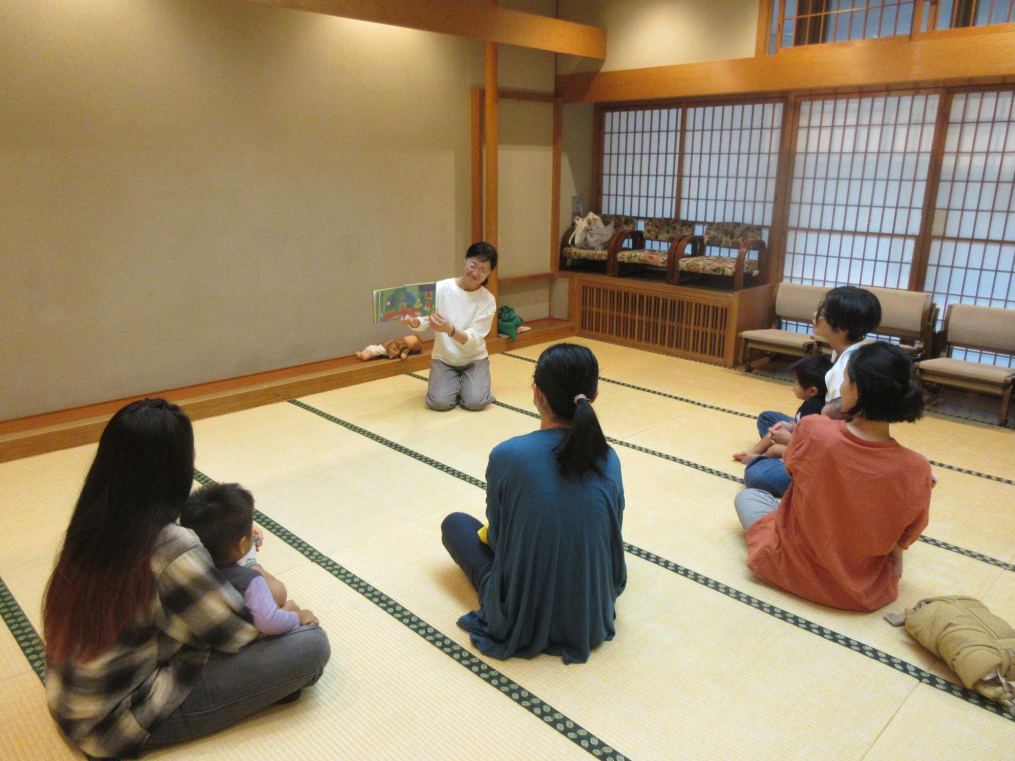 親子が絵本の読み聞かせをしてもらう様子