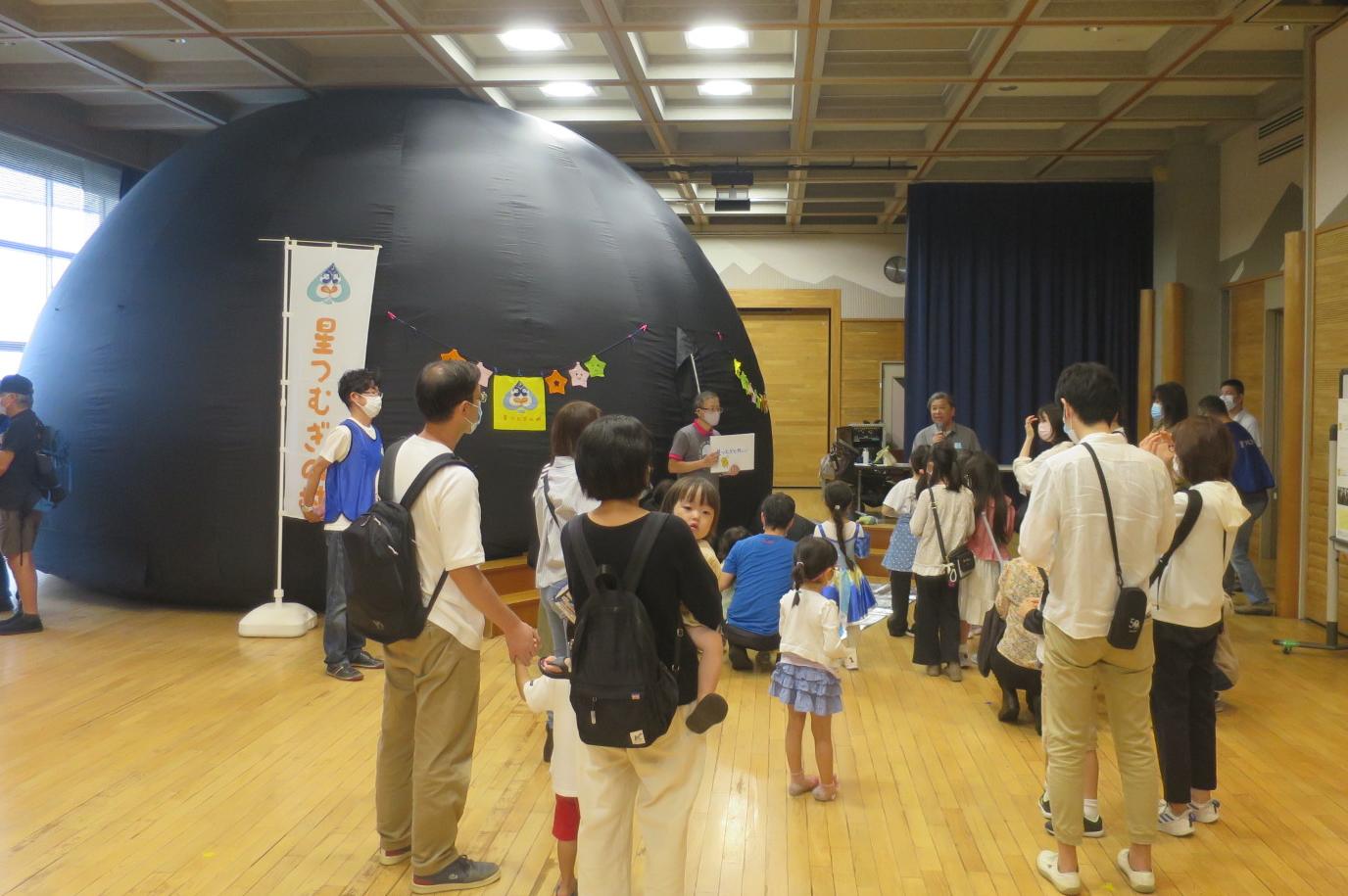 参加者がプラネタリウムの説明を受ける様子