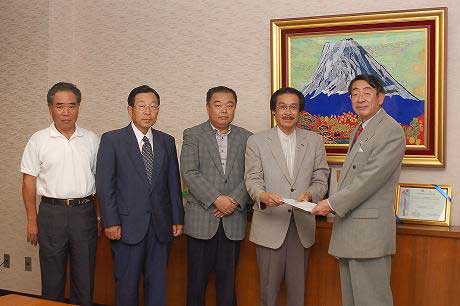 秋山委員、齊藤委員、山内副委員長、斉藤委員長、古谷市長が室内で並んで立ち、斉藤委員長が古谷市長に報告書を手渡している場面を捉えた写真