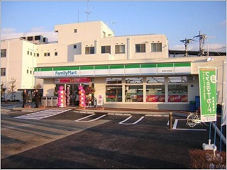 駐車場に面して建つ平屋のファミリーマートの外観写真