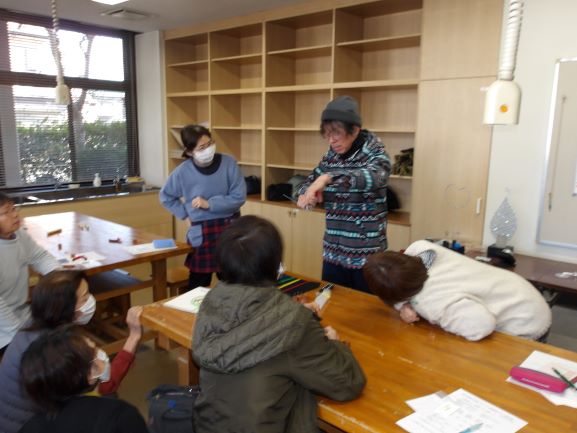 講師がワイヤーをニッパでハート型に形成しているところ参加者が見ている