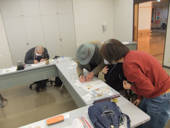 長机の上で講師が参加者に指導をしている