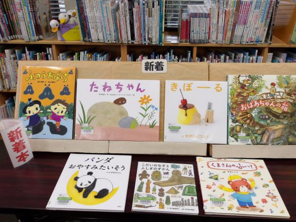 図書室の机の上に新着本で絵本が平置きと面設置している