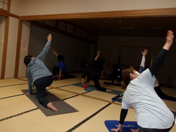 和室で数人の女性がヨガのポーズをしている