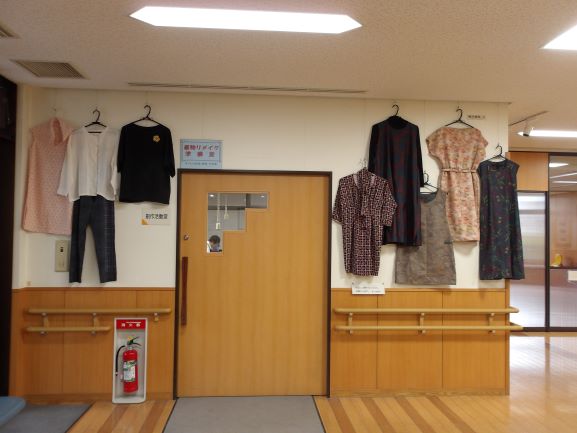 壁面に着物をリメイクした洋服が7着飾ってある