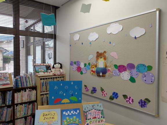 図書室の壁面に熊と傘をさしたうさぎと紫陽花の切り絵がはってある