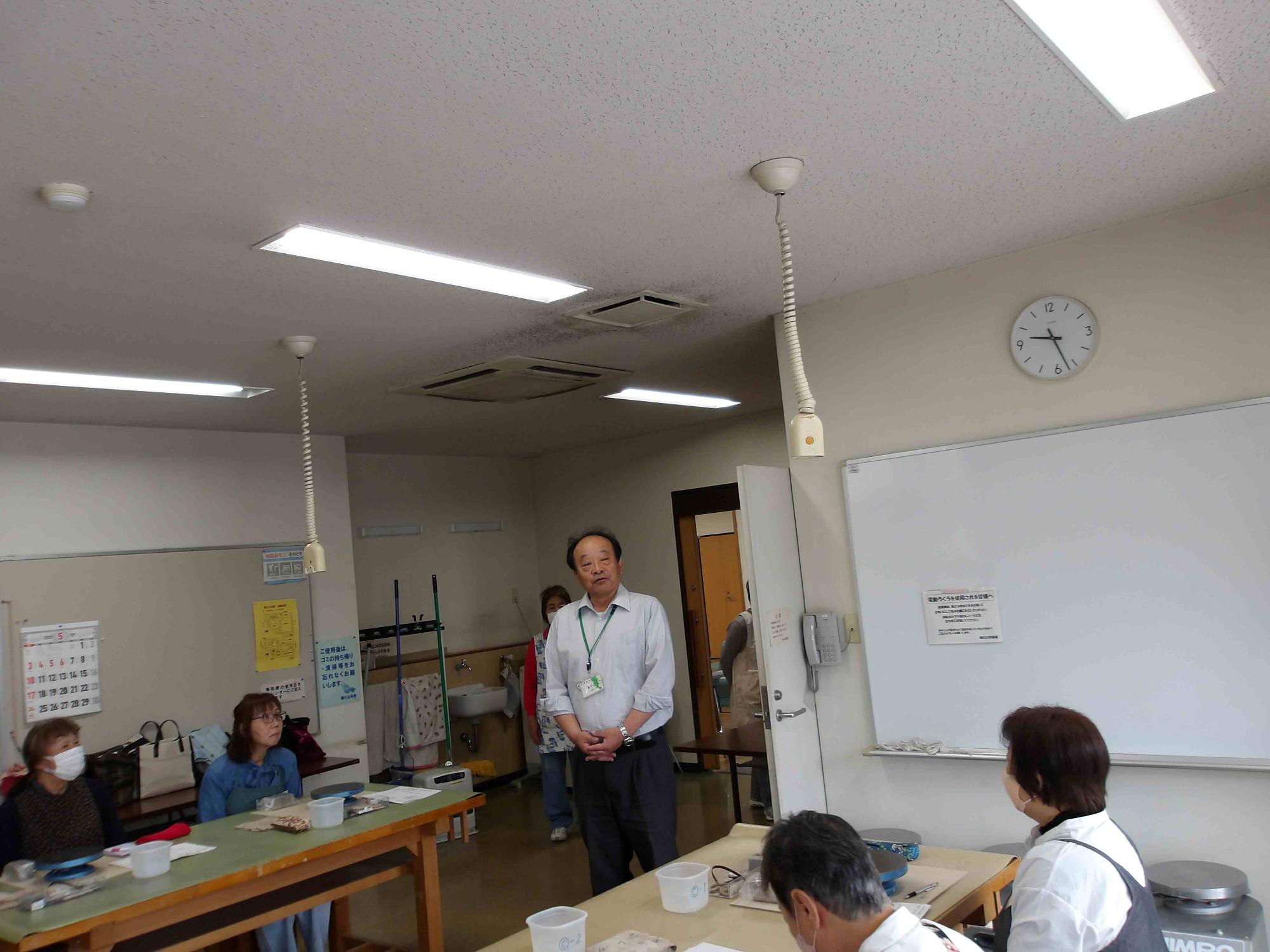 大人の男性が講座参加者に挨拶をしている