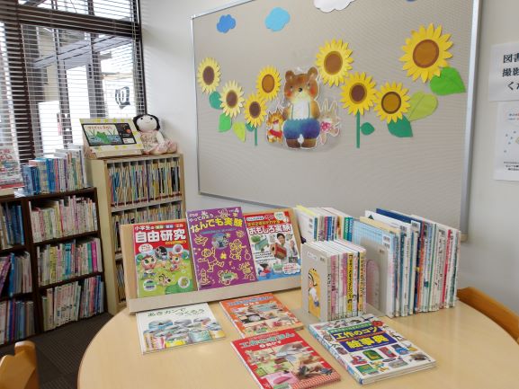 図書室の壁面に熊とうさぎと8本のひまわりの切り絵が貼ってある