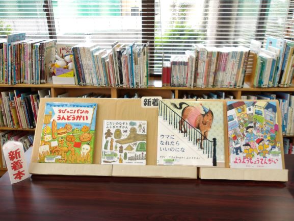 図書室の机の上に新着本で絵本が斜めに4冊置いてある
