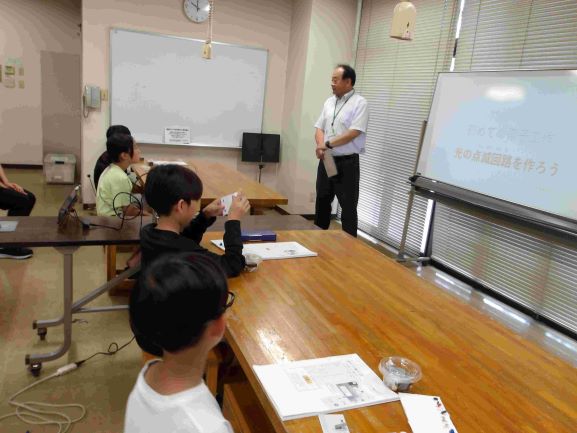 大人が一人前に立ち子どもたちが話を聞いている