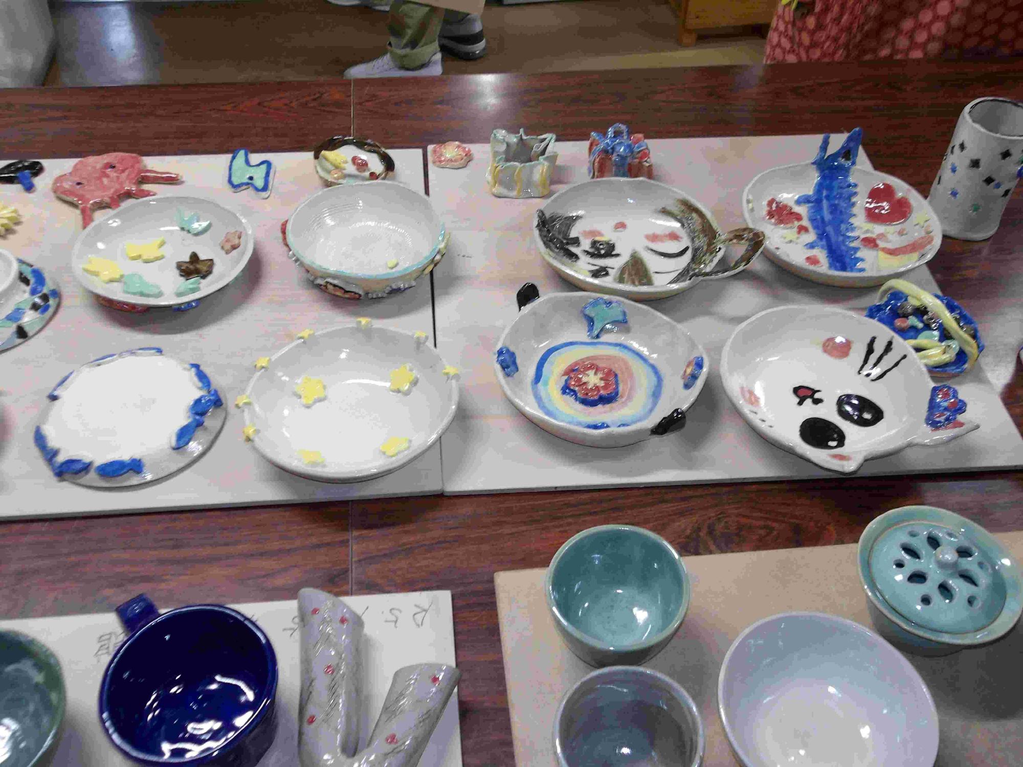 机の上に夏休み子ども陶芸で作ったお皿やお椀などが並んでいる