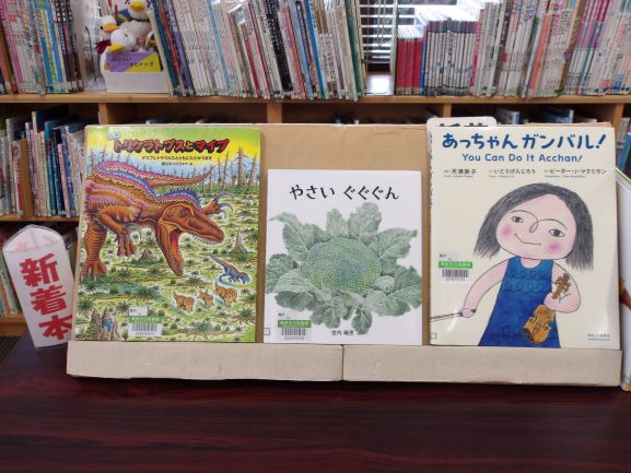 図書室の机の上に新着本で絵本が斜めに3冊置いてある