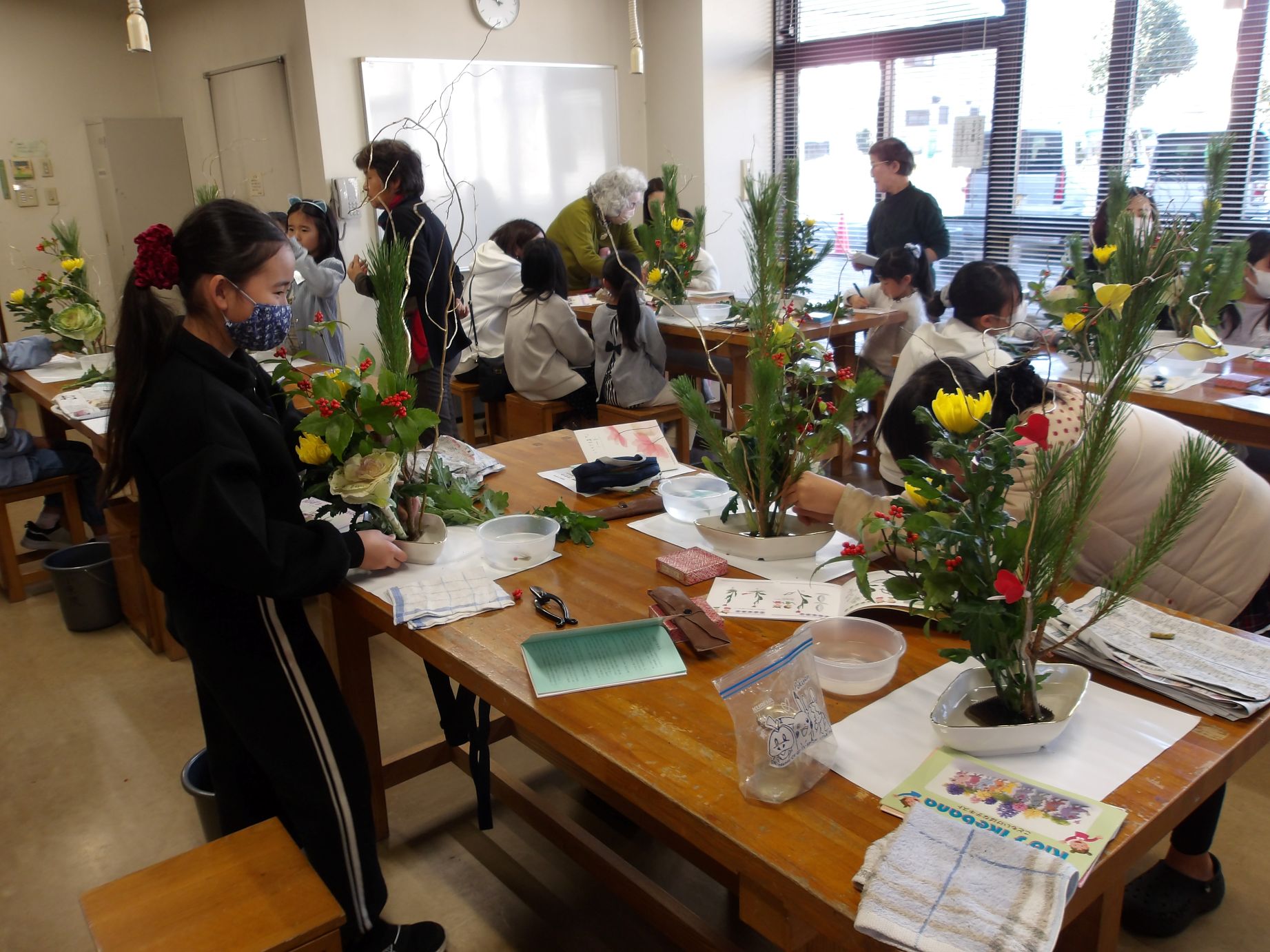 子ども生け花教室の講座風景で子どもたちがお正月向けの菊や松を生けている
