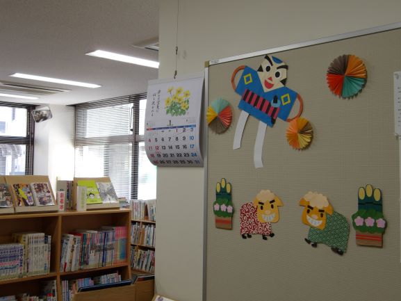 図書室の壁面に凧あげや獅子舞の絵が貼ってある