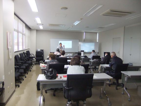 久保田さんが、ホワイトボードを指差しながら生徒たちに説明をしており、複数の生徒が机に向かい熱心に耳を傾けている様子の写真