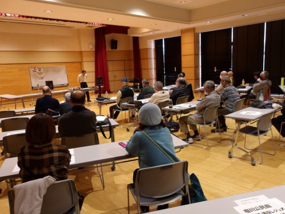 多目的ホールで受講者を前に講師がはなしている