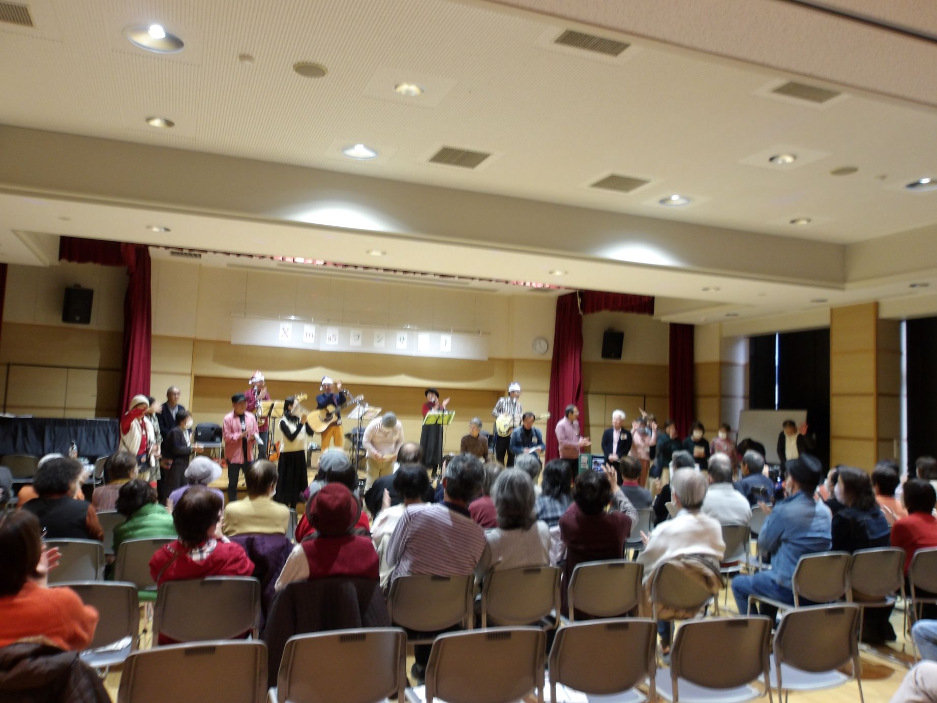 クリスマスコンサートで出演者と観客が写っている