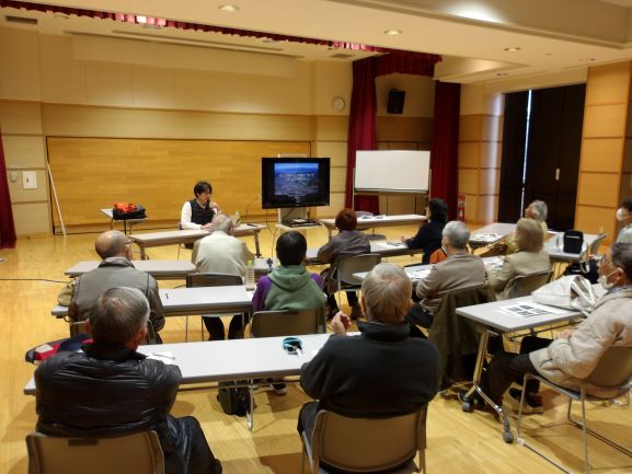 講座の風景で講師が前に座り、受講者にモニターの写っている画像の説明をしている