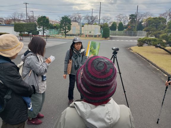 外で講師が前にたちフイールドスコープが2台あるところで受講者に説明