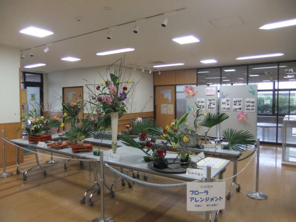 ロビーの中央に長机並べその上にフラワーアレジメントの作品を多く展示してある