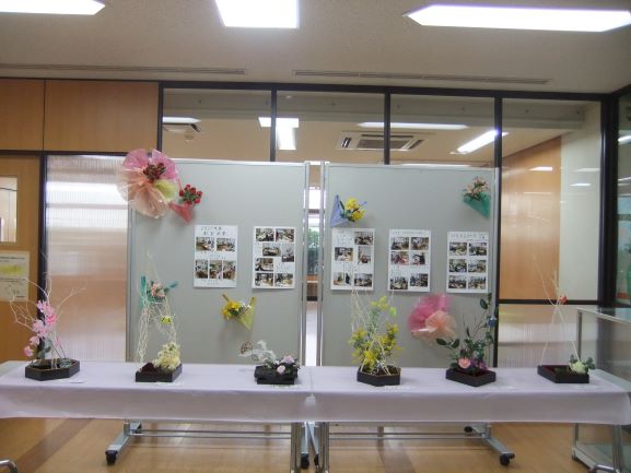 パネルの前に子どもが生けた版画6個飾ってある