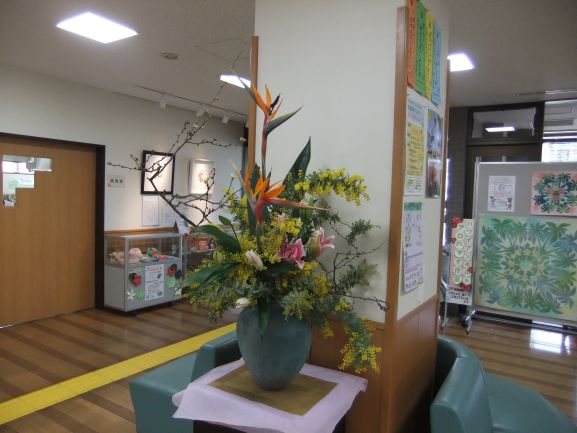 ロビーに大きな水色の花瓶にミモザなどの多くの花が生けてある