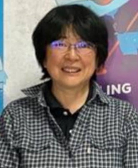 黒と白のギンガムチェックのシャツにメガネをかけた延與 桂さんがまっすぐ正面を見ている写真