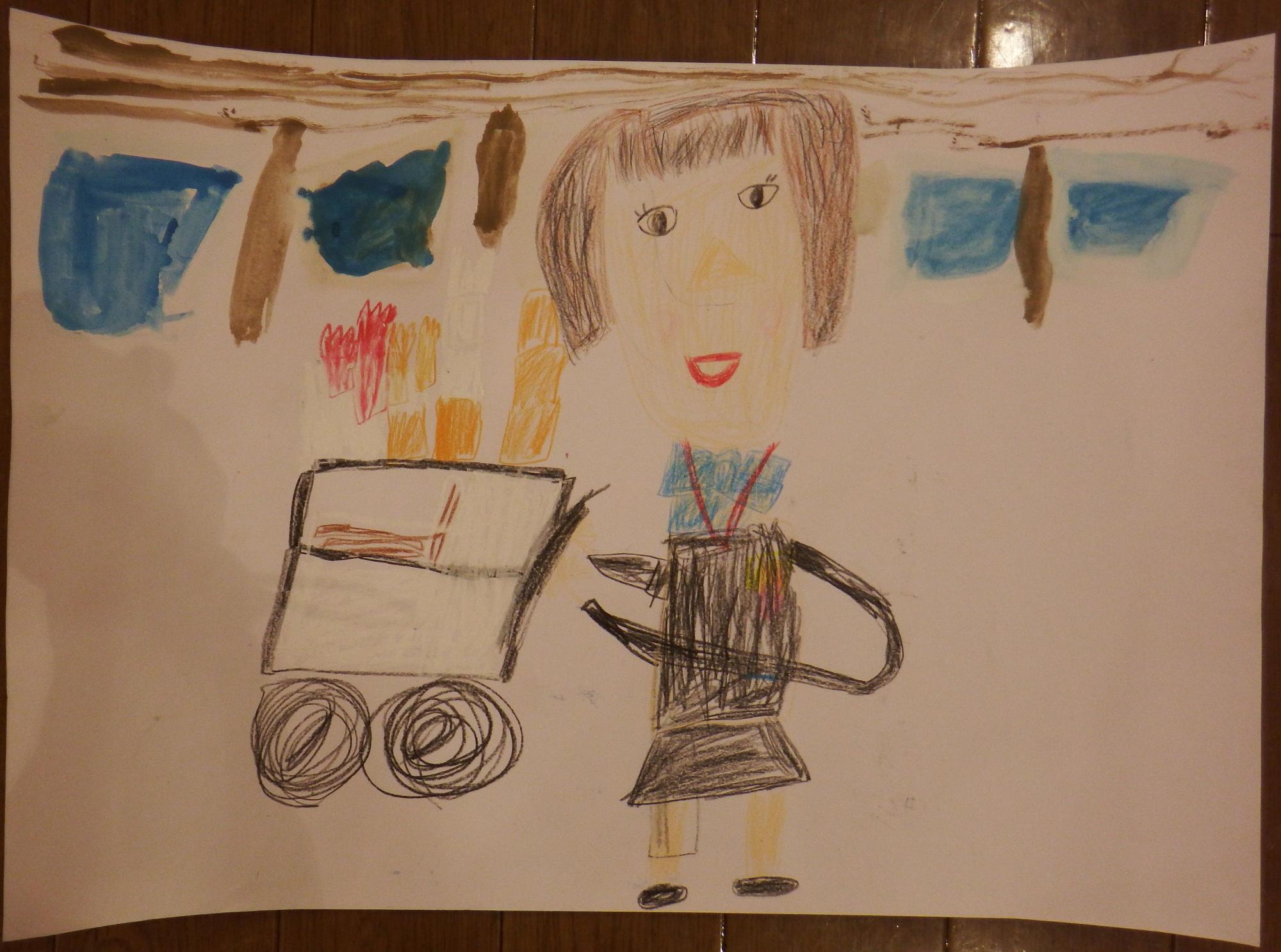 青色のリボンに黒い制服を着た客室乗務員の女性が笑顔で、商品を乗せた車輪のついたカートを押している様子が大きくクレヨン画で描かれている入選受賞作品の写真