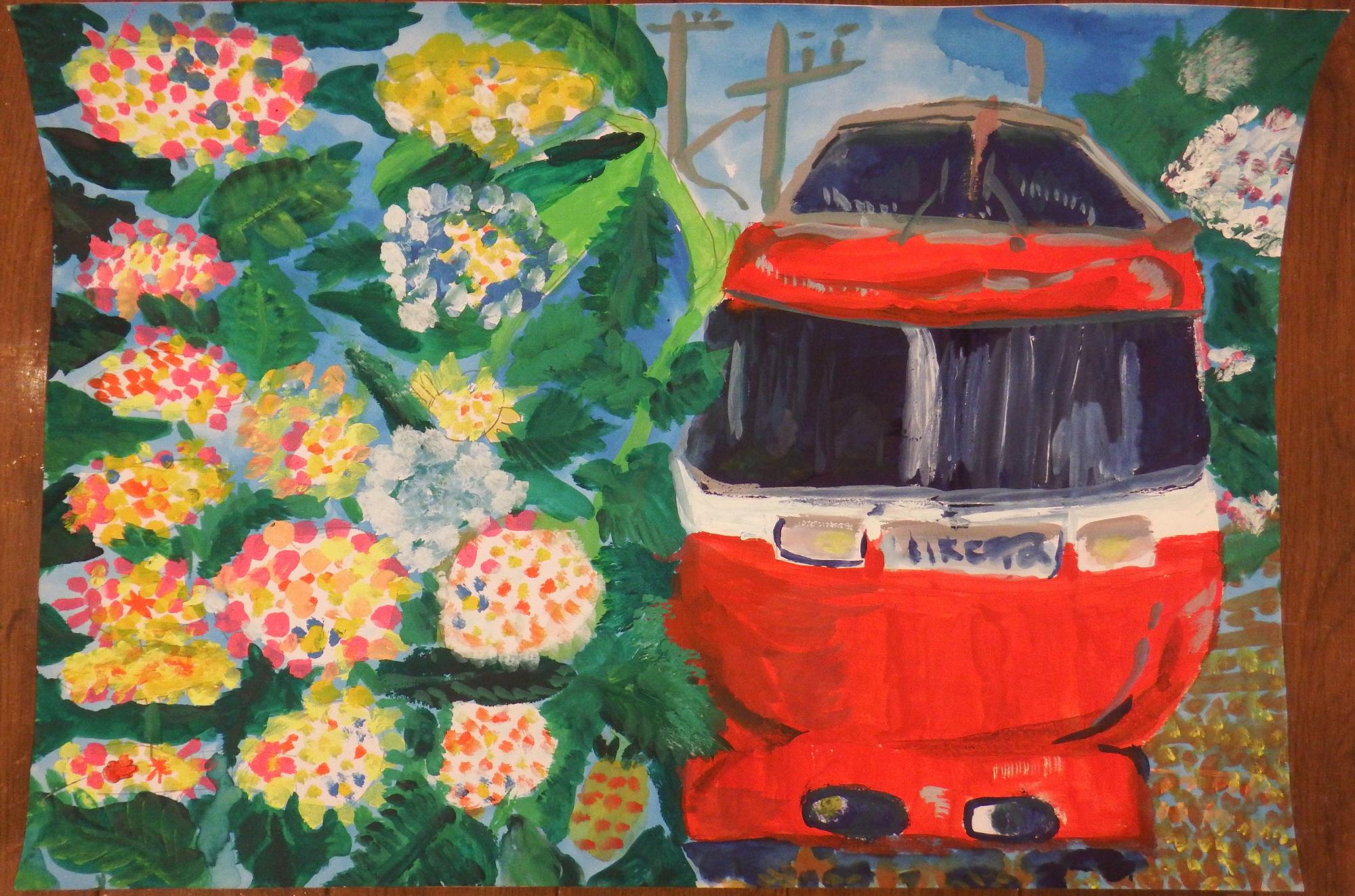 赤や青色の紫陽花の花々が咲き誇る風景の中を、白いラインの入った赤い電車が走る様子を正面から描いており、色とりどりの紫陽花と緑の葉が画面を埋め尽くすように表現された入選受賞作品の写真