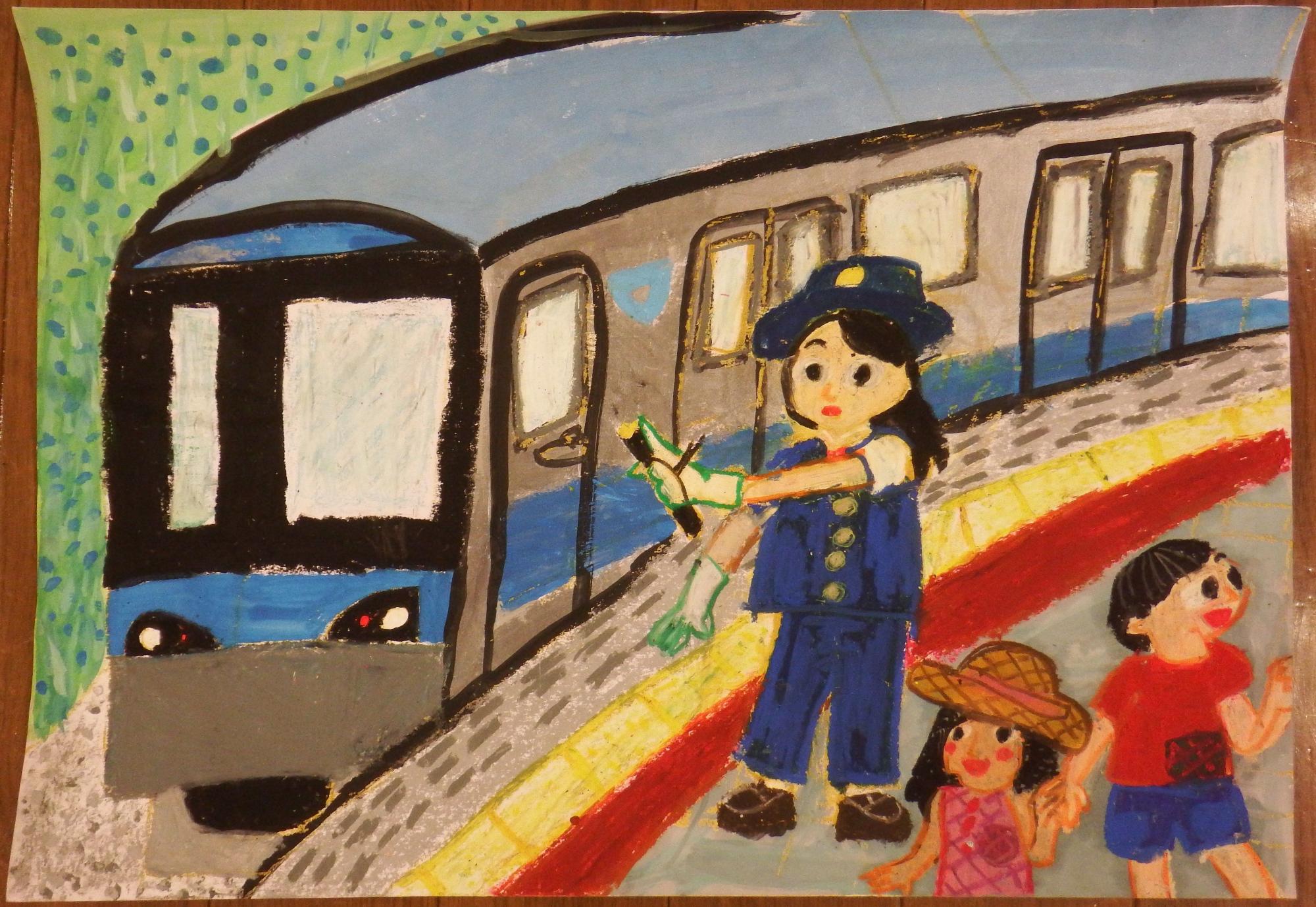駅のホームに停車している青いラインの入ったグレー色の電車と、両手に手袋をした女性の駅員が先端が黄色い棒を持って立ち、その横で帽子をかぶった女の子を含む二人の子供が手をつないで楽しそうにしている様子を描いた絵画の入選受賞作品の写真