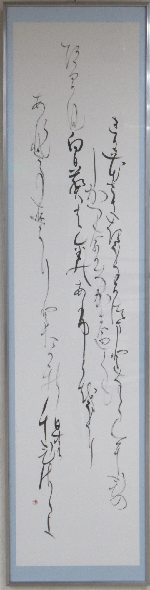 枠に入った縦長の白い和紙に墨で書かれ、流れるような崩し字で表現した、書道の部で市展大賞を受賞した作品の写真