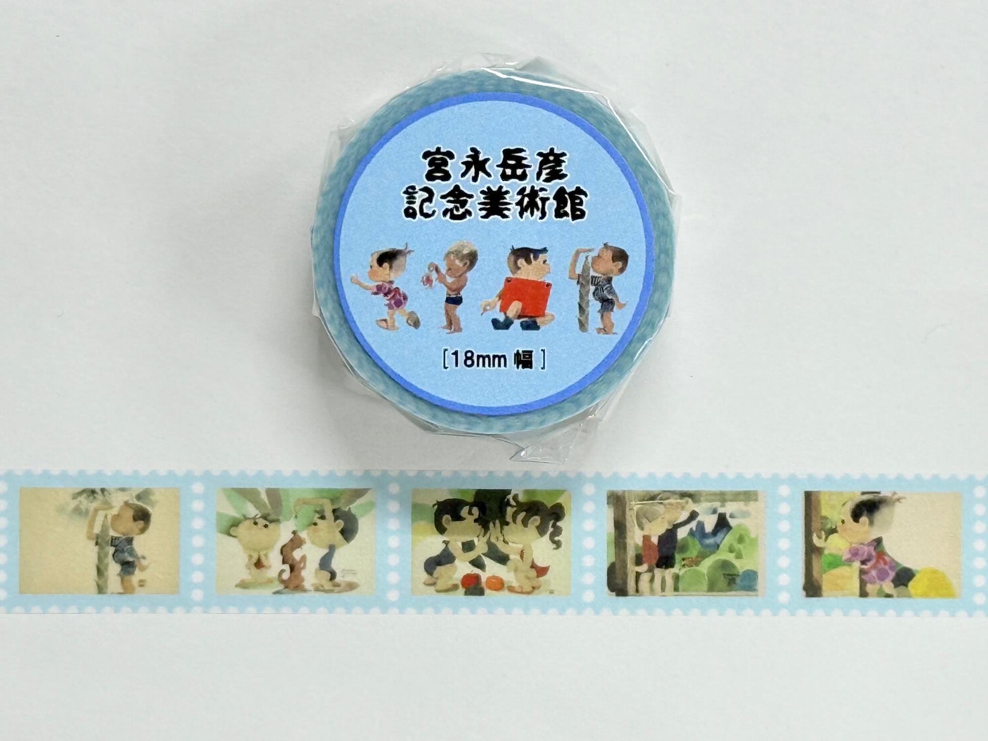 水色の台紙に「宮永岳彦記念美術館」の文字と四人の子供のイラストが描かれたマスキングテープのパッケージと、水色の枠と水玉模様の中に子供たちの絵が繰り返し印刷されたマスキングテープが広げられた状態の商品写真