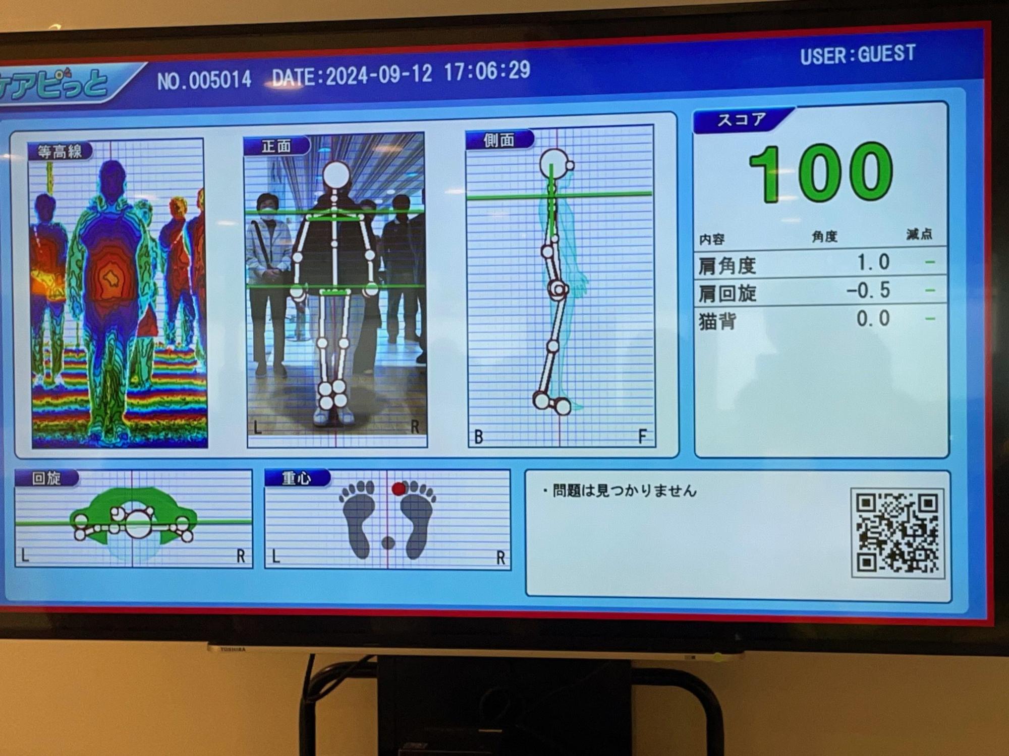 人の姿勢や重心を分析し、全身を等高線や骨格で可視化した画像を伴う、スコアや詳細な分析結果が表示されている健康測定機器のディスプレイ画面を写した写真