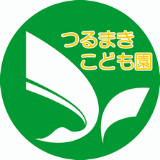 緑色の円形の中に翼をひろげた鶴のマークが白く描かれた、つるまきこども園園章の画像