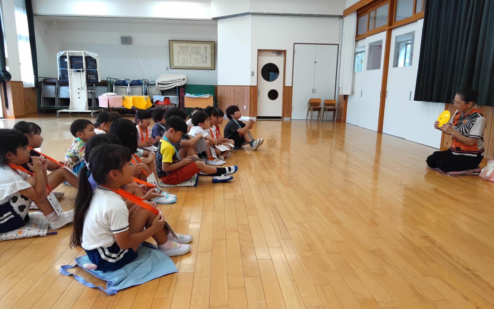 5歳児が英語講師の前に座って指導を受けている写真