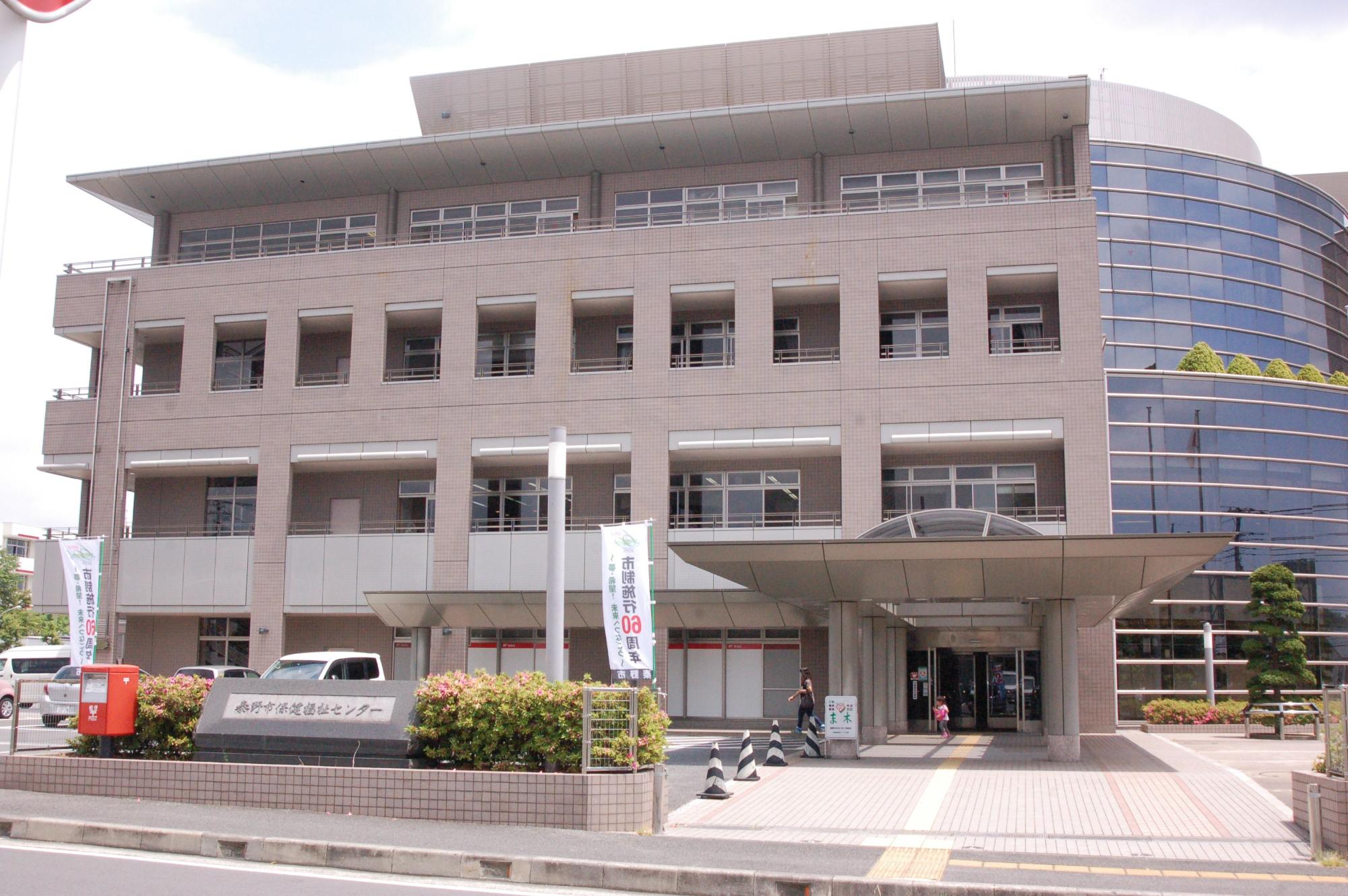 ガラス張りの円形部分を持つモダンな保健福祉センターの外観写真