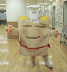 秦野市食育キャラクターボンチーヌが室内で両手を広げて立っている写真