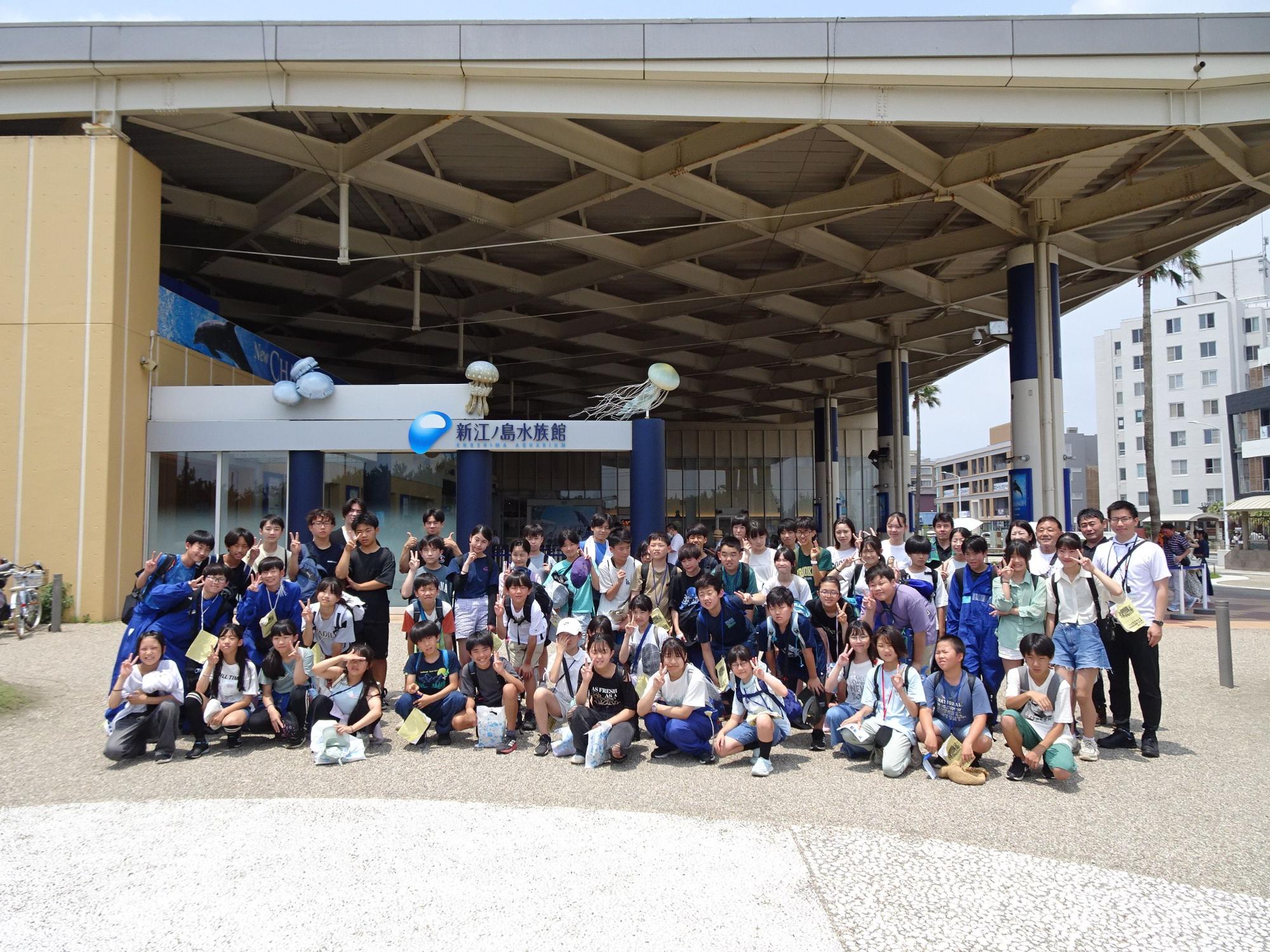 新江ノ島水族館のエントランス前で、複数の子供達や大人が集合しポーズをとっている写真