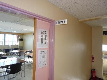 「高校生学習室」と書かれた部屋札と張り紙が貼られたピンク色のドアから室内を写した写真