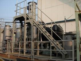 複数のタンクと複雑な配管、それらを繋ぐ階段と手すりが一体となった深層地下水浄装置の写真