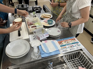 調理実習室で参加者が食材や調理器具を使って料理の準備をしている様子を写した、指導者養成講座の写真