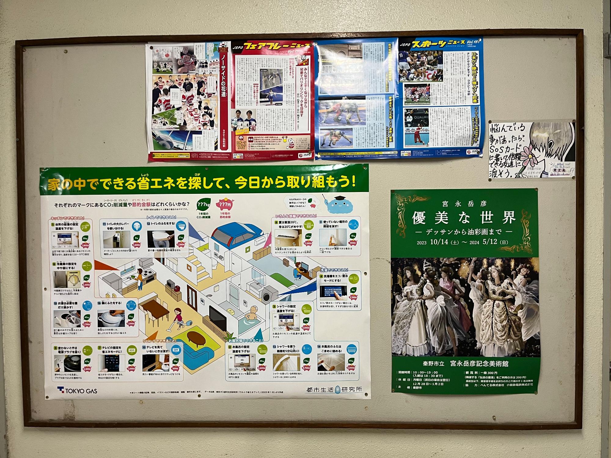 掲示板に省エネ活動や関連イベントの情報が掲載されたポスターやチラシが貼られており、地域への啓発が行われている様子を写した、省エネ啓発掲示の写真