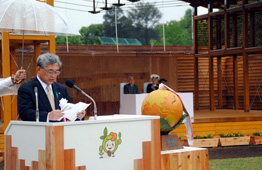 木目調の式典会場で、国土緑化推進機構理事長が白い演台の前で大会宣言をしている写真