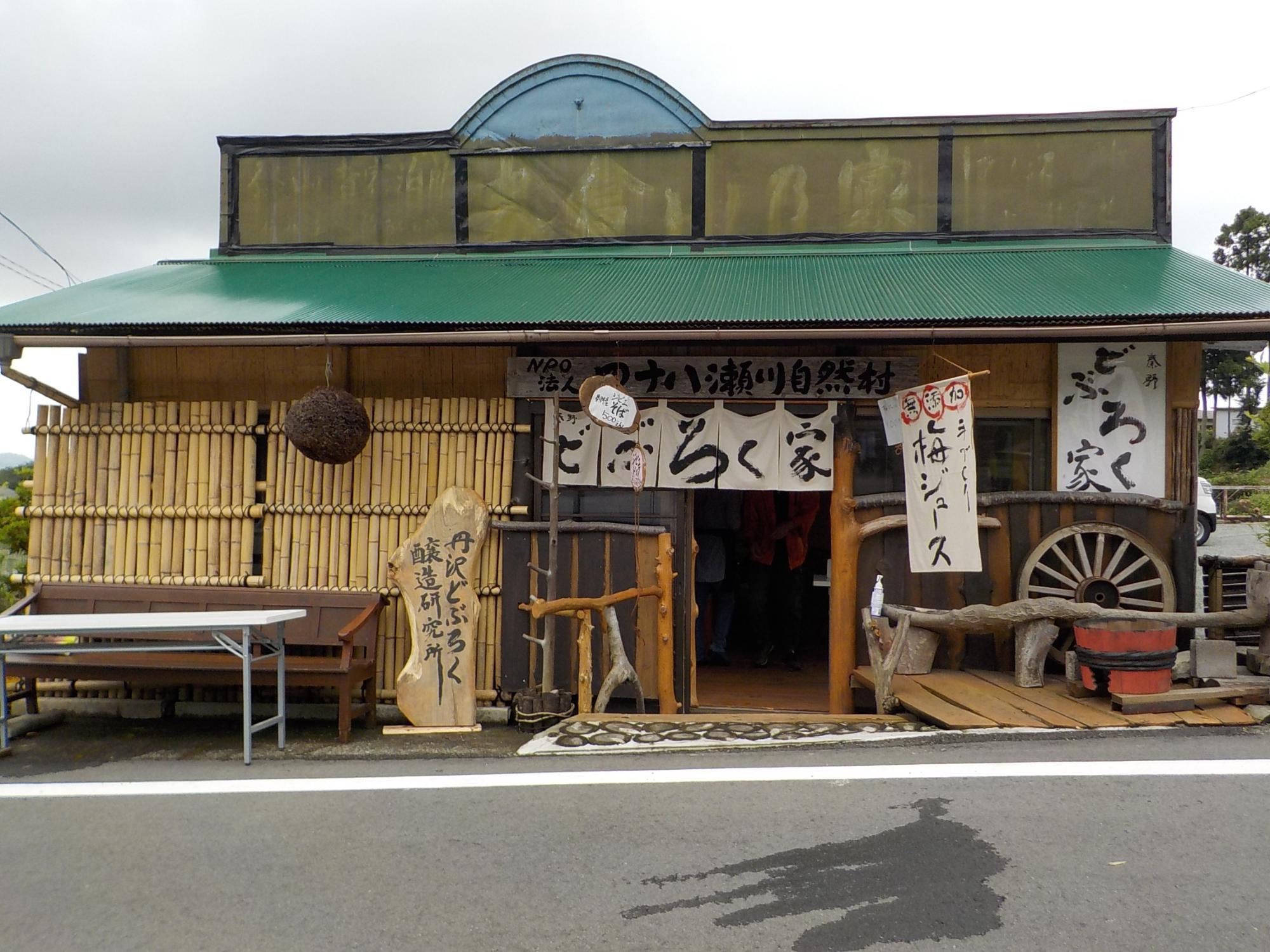 緑色のトタン屋根と竹の壁が特徴的な、和風の素朴な農家レストラン 秦野どぶろく家の外観写真